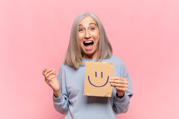 Femme d'âge moyen avec visage souriant peint sur carton