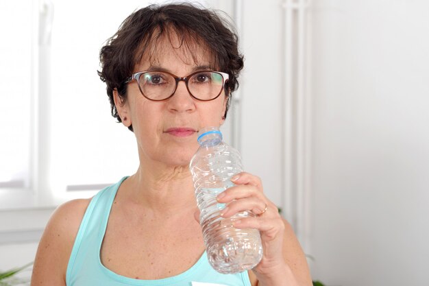 Femme d'âge mûr belle remise en forme avec une bouteille d'eau