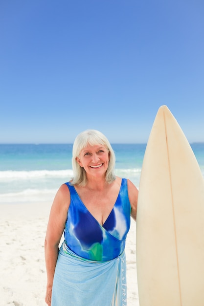 Femme d&#39;âge mûr avec sa planche de surf