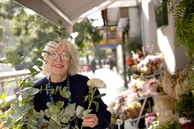 femme âgée achetant des fleurs dans un magasin de fleuristes