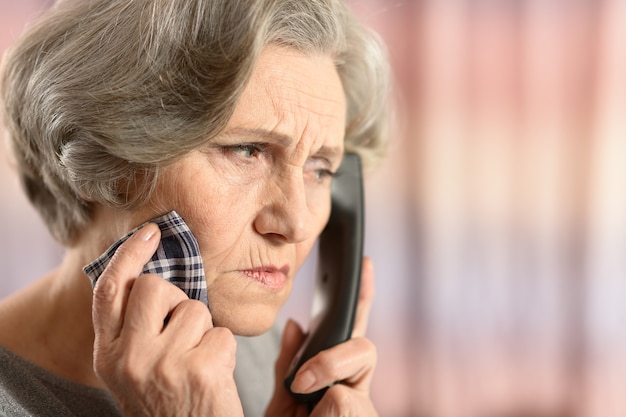 Femme âgée appelant un médecin isolé sur fond coloré