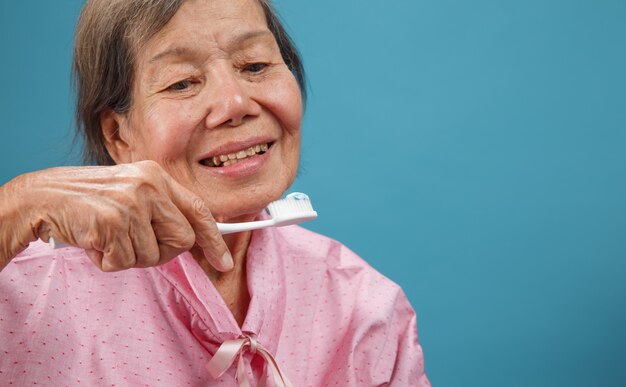 Femme âgée asiatique à l'aide d'une brosse à dents