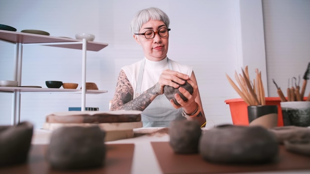 Femme âgée asiatique appréciant le travail de poterie à la maison Une femme céramiste fabrique de nouvelles poteries dans un studio