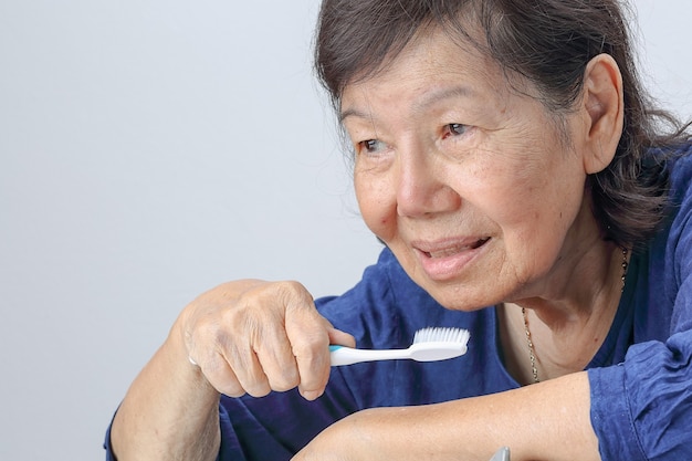 Femme âgée asiatique avec une brosse à dents. Santé dentaire