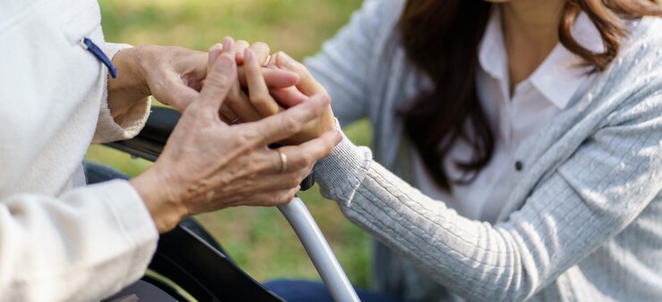Femme âgée asiatique en fauteuil roulant avec fille heureuse Relation familiale femme à la retraite assise sur un fauteuil roulant dans le parc soins d'âge à la maison de retraite