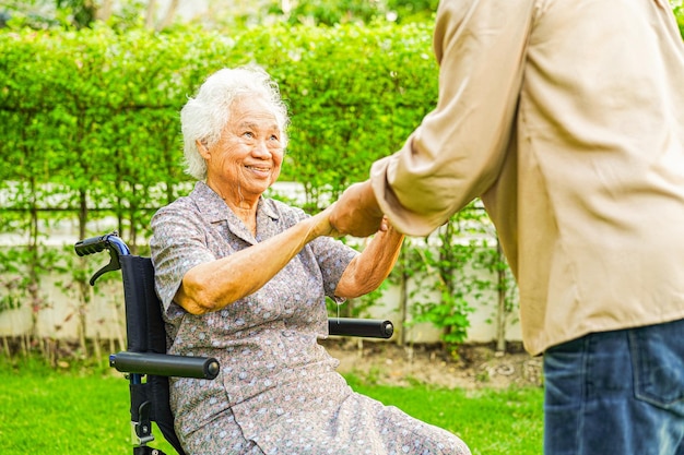 Femme âgée asiatique handicapée patiente assise sur un fauteuil roulant dans le concept médical du parc