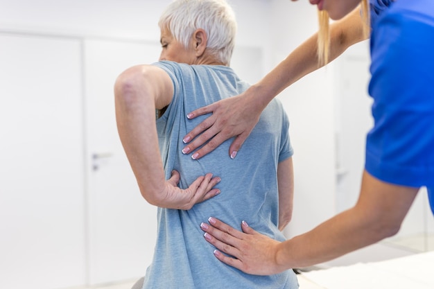 Femme âgée ayant un ajustement chiropratique du dos Ostéopathie Concept de médecine alternative de soulagement de la douleur Physiothérapie réadaptation des blessures