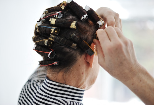 Femme âgée avec des bigoudis sur les cheveux