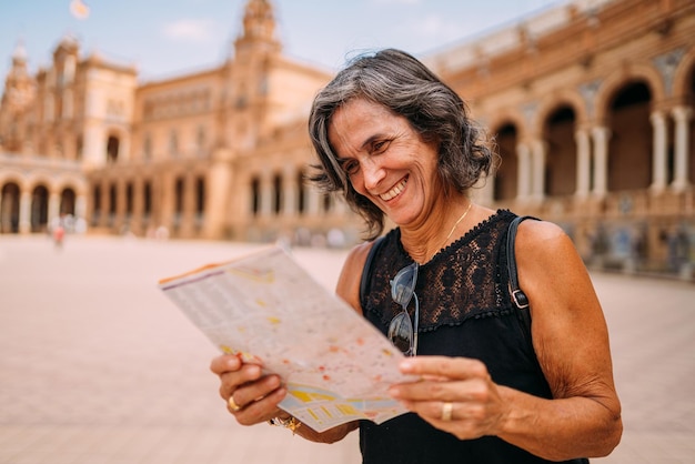 Femme âgée à la carte pour décider quoi visiter dans la ville Femme âgée voyageant en Europe