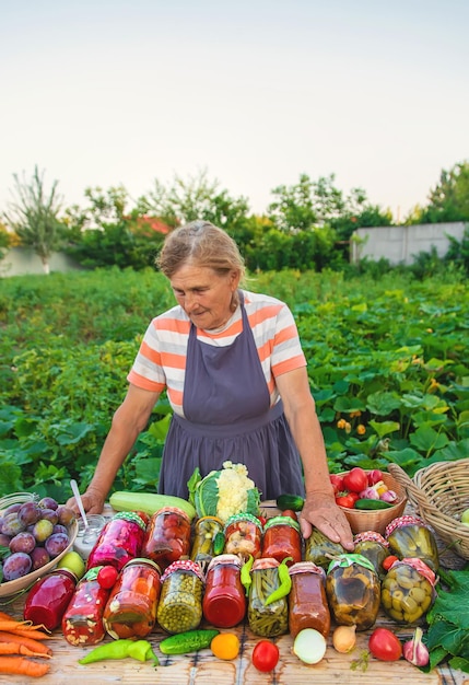 Femme âgée conservant des légumes dans des bocaux Mise au point sélective