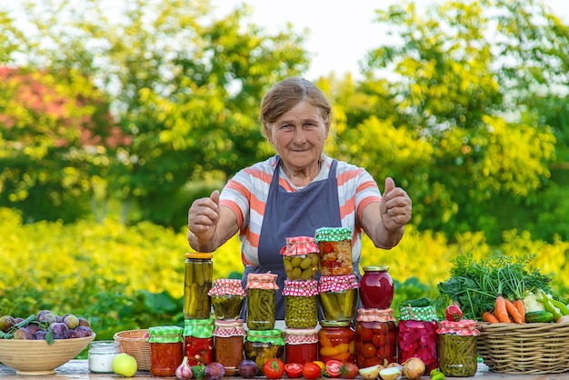 Femme âgée conservant des légumes dans des bocaux Mise au point sélective