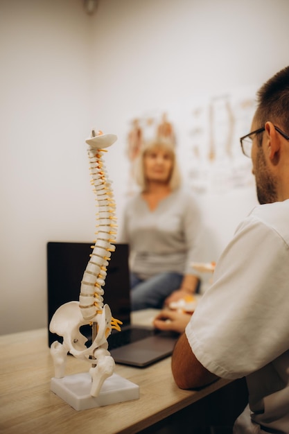 La femme âgée dans le bureau du médecin elle a des douleurs au dos et des symptômes de rhumatisme