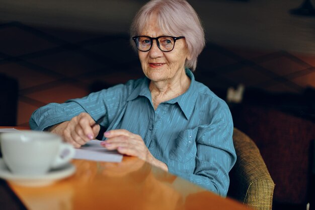 Femme âgée dans un café une tasse de boisson portable Réseaux sociaux inchangés