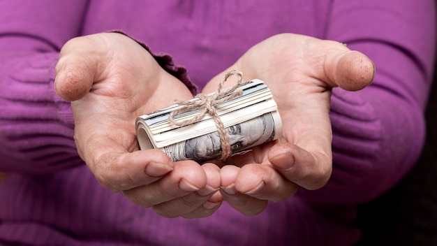 Une Femme âgée Détient De L'argent Dans Ses Mains