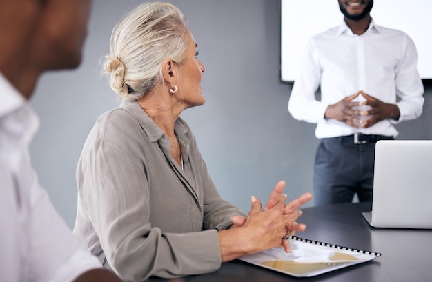 Femme âgée écoutant et coachant lors d'une réunion de présentation pour la stratégie d'entreprise au bureau Personne de sexe féminin mature ou PDG avec un homme d'affaires ou un entraîneur formant le personnel dans la salle de conférence sur le lieu de travail