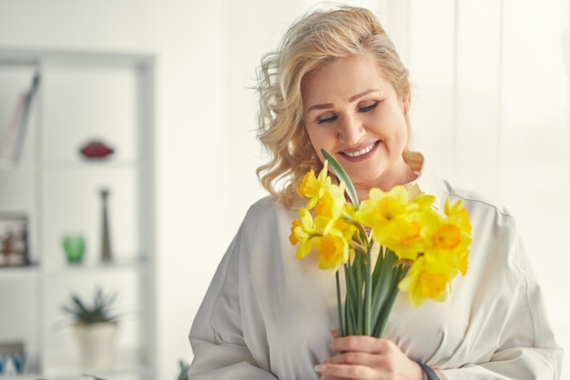 Femme âgée élégante avec des fleurs