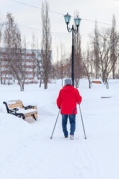 Une femme âgée est engagée dans une promenade scandinave en hiver