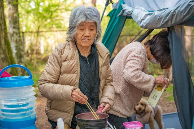 Femme agée faisant cuire au camp