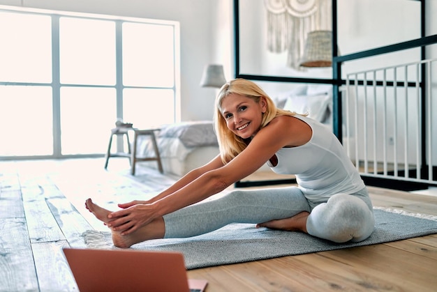 Femme âgée faisant du sport à la maison