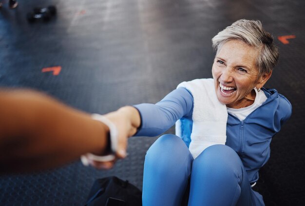 Femme âgée fitness et entraîneur personnel avec soutien et exercice d'entraînement heureux et santé musculaire sur le sol de la salle de gym