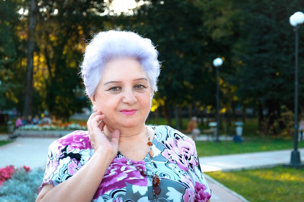 Femme agée sur un fond de végétation de parc