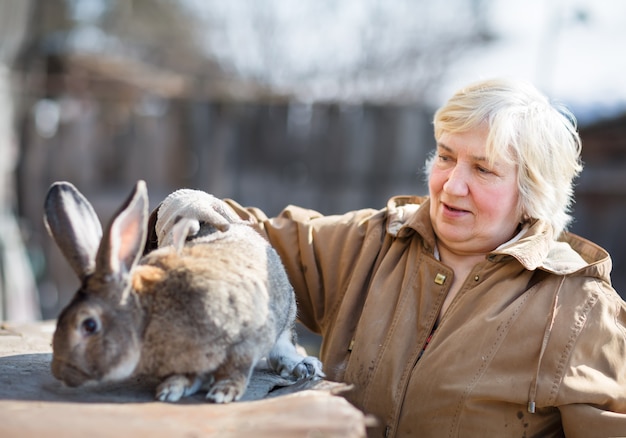 Femme âgée avec une grande ferme de lapin