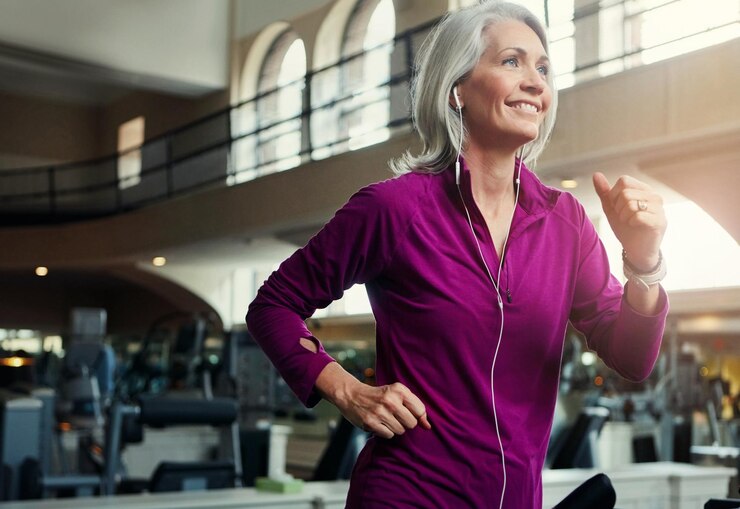 Photo femme âgée heureuse et courant sur un tapis roulant pour le bien-être, l'exercice et la forme physique à la retraite femme excitée et s'entraînant au gymnase pour l'entraînement cardio, la vitalité physique et la force du corps