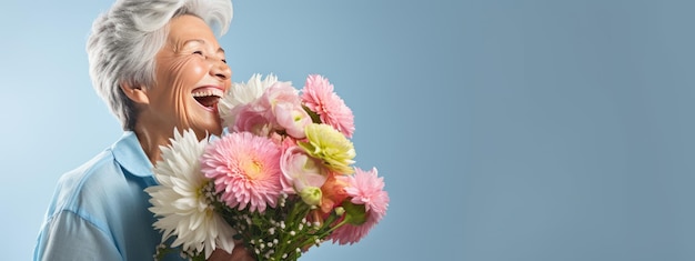 Une femme âgée heureuse tient un bouquet de fleurs dans ses mains.