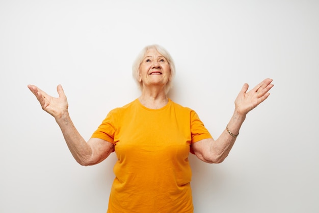 Femme âgée joyeuse en gestes de t-shirt décontracté avec ses mains vue recadrée