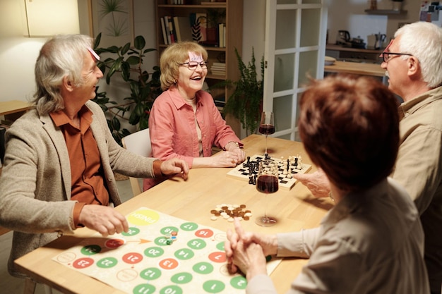 Femme âgée joyeuse riant en jouant au jeu de noms avec des amis