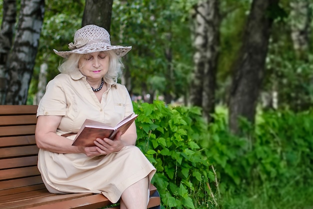 Une Femme âgée Lit Un Livre Dans Le Parc