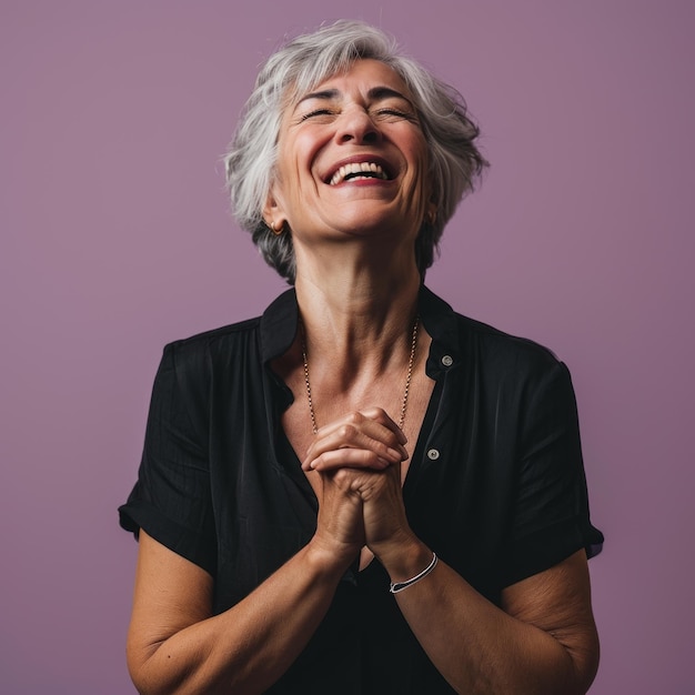 Une femme âgée avec les mains sur la poitrine et un sourire sur le visage.