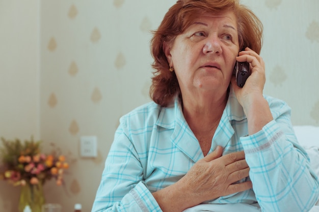 Femme âgée malade appelant son médecin. Concept de soins de santé des personnes âgées.