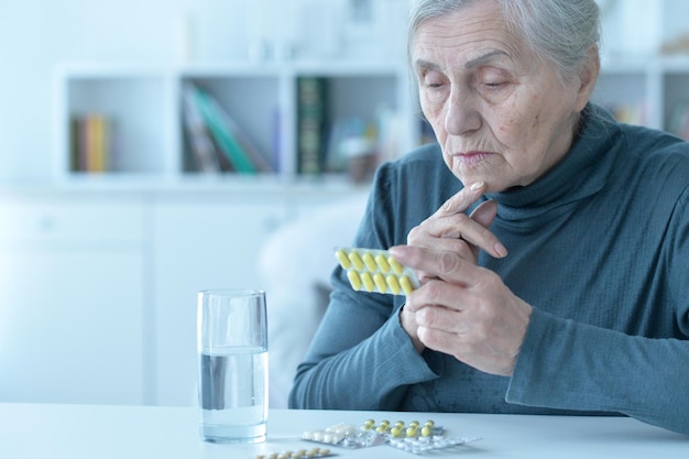 Femme âgée malade prenant des médicaments