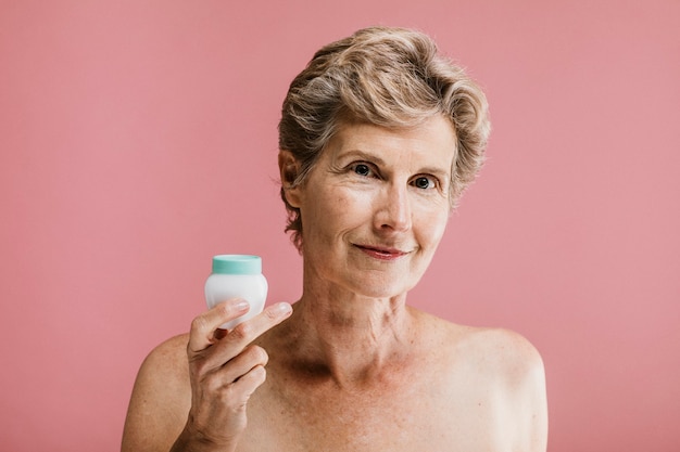 Femme âgée avec une maquette de conteneur de crème