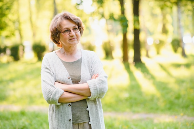 Femme âgée marchant dans le parc en été