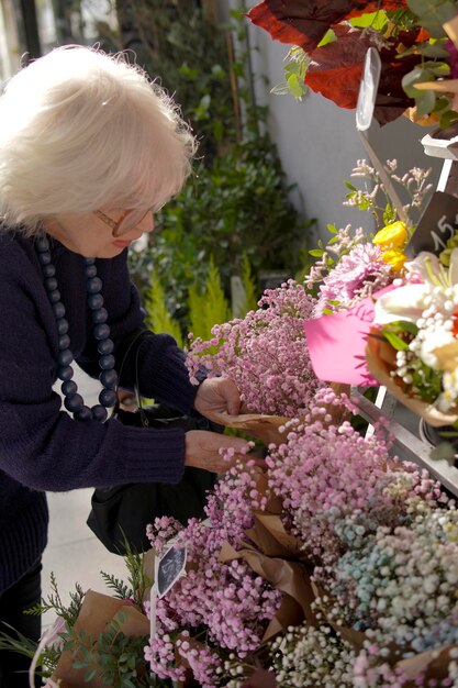 femme âgée méconnaissable dans une boutique de fleurs