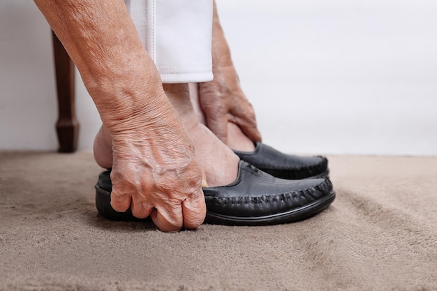 Femme âgée mettant des chaussures