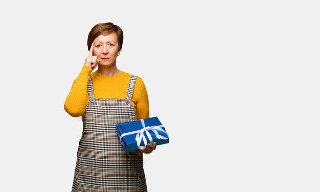 Femme âgée moyenne célébrant la Saint-Valentin en faisant un geste de concentration