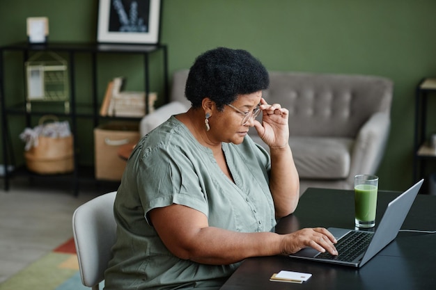 Femme âgée noire à l'aide d'un ordinateur portable