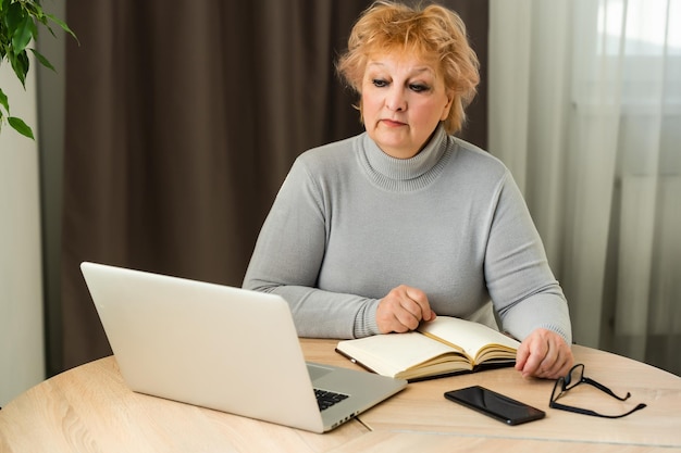 La femme âgée à l'ordinateur portable.