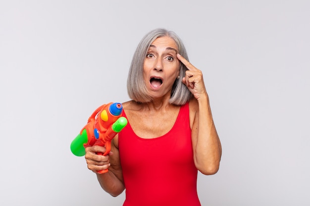 femme âgée avec un pistolet à eau