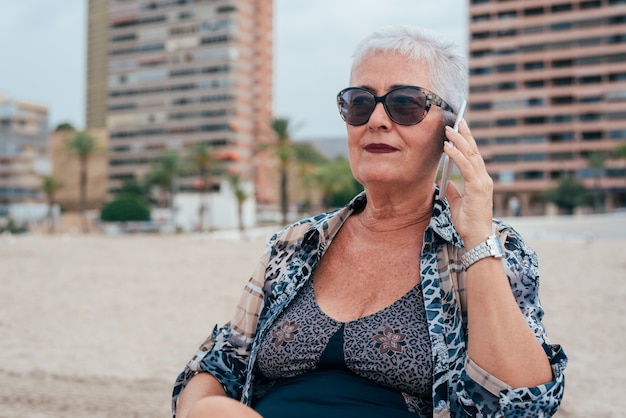 Femme âgée, plage, téléphone portable