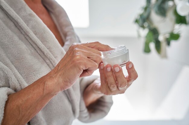 Photo une femme âgée sur le point d'appliquer une crème pour le visage