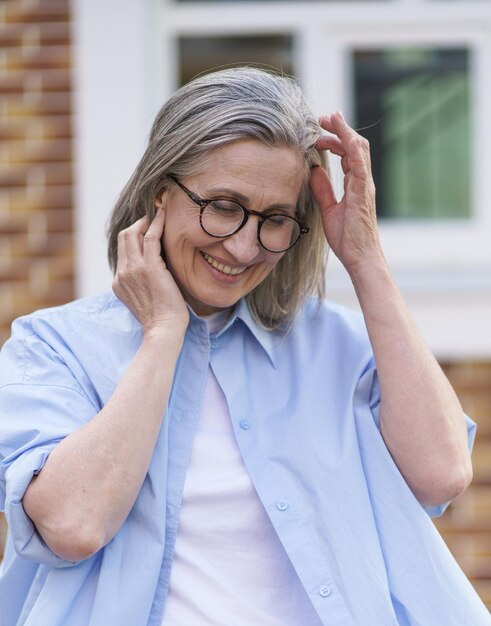Photo une femme âgée portant des lunettes et une chemise bleue