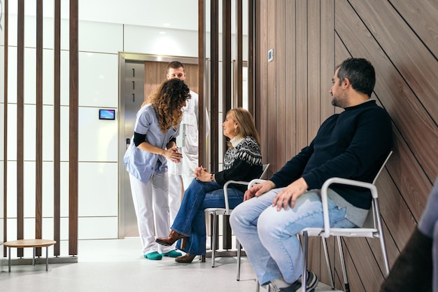 Photo une femme âgée pose une question à une infirmière dans une salle d'attente d'un hôpital.