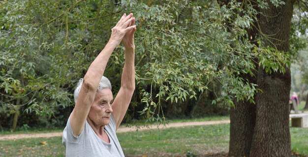 Femme âgée pratiquant le yoga en plein air