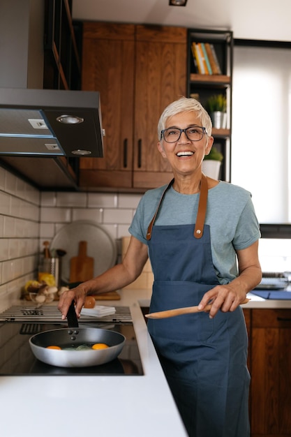 Femme âgée préparant un délicieux déjeuner dans la cuisine