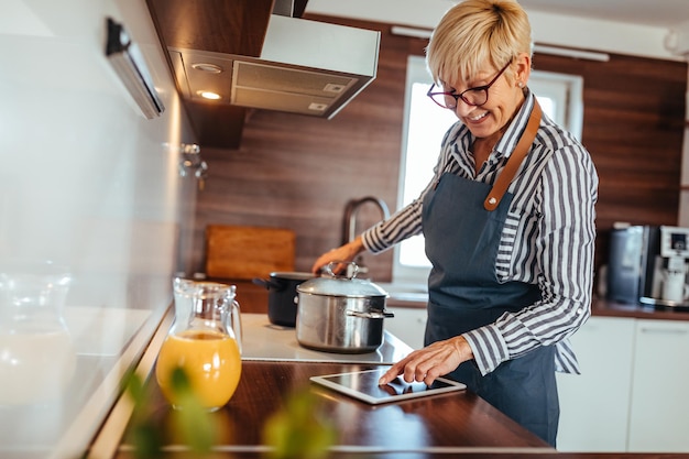 Femme âgée préparant un délicieux repas dans la cuisine