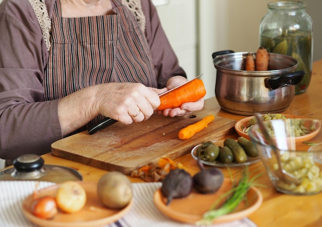 Photo une femme âgée prépare une vinaigrette de betteraves et de légumes bouillis